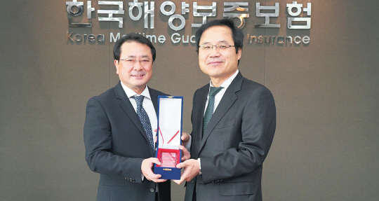 SK주식회사 C&C는 한국해양보증보험 대표이사 최재홍 사장으로부터 '한국해양보증보험 업무시스템' 구축 사업을 단기간에 성공적으로 완료한 공로로 감사패를 받았다. 왼쪽부터 최재홍 한국해양보증보험 대표, 백형덕 SK주식회사 C&C 상무.  SK주식회사 C&C 제공